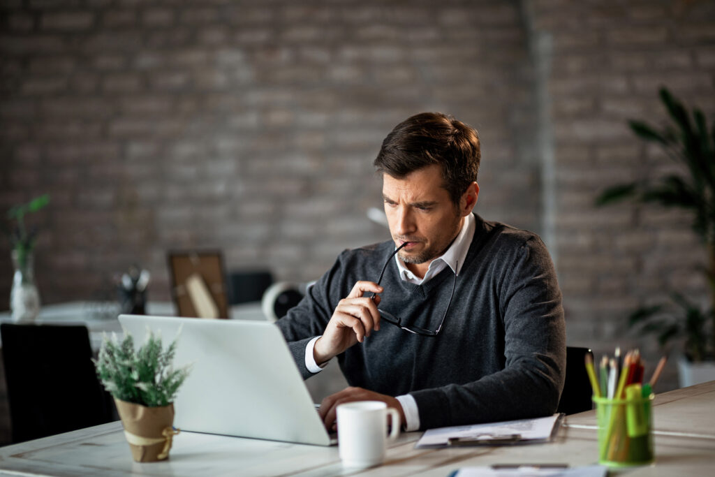 serious-businessman-using-laptop-work-contemplating-about-email-he-has-received